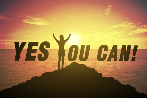 Silhouette of a person standing on a rocky peak with arms raised victoriously against a sunset over the ocean, with the inspirational message 'YES YOU CAN!' in bold letters across the sky.